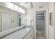 Bathroom vanity with granite countertop, sink, mirror, and a view of the shower at 380 Three Lakes Ln # E, Venice, FL 34285