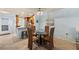 A view of the dining area with a glass-top table, wooden chairs, and an adjacent kitchen at 380 Three Lakes Ln # E, Venice, FL 34285