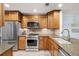 Updated kitchen featuring stainless steel appliances, granite countertops, and wood cabinetry at 380 Three Lakes Ln # E, Venice, FL 34285