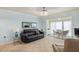 Living room with black leather sofa, light tile flooring, and access to the enclosed balcony at 380 Three Lakes Ln # E, Venice, FL 34285