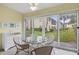 Patio with a glass table and chairs overlooking a grassy area and trees at 380 Three Lakes Ln # E, Venice, FL 34285
