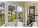 View from the patio showing the community grounds, including palm trees and a small lake at 380 Three Lakes Ln # E, Venice, FL 34285