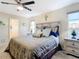 Comfortable bedroom featuring a ceiling fan, wooden floors, and a decorative dresser and mirror at 4 Windsor Dr, Englewood, FL 34223