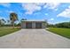 Two-car garage with metal roof and large concrete driveway at 4130 Rock Creek Dr, Port Charlotte, FL 33948