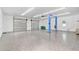 Bright garage interior with epoxy flooring, two garage doors, and a car lift at 4130 Rock Creek Dr, Port Charlotte, FL 33948