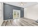 Living room with grey accent wall, vinyl plank flooring, and French doors at 4130 Rock Creek Dr, Port Charlotte, FL 33948
