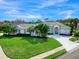 Aerial view of a single-story home with a tile roof, lush landscaping, and a paved driveway at 4151 Natale Dr, Venice, FL 34293