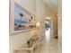 Bright and airy entryway with glass-top table and beach-themed art at 4417 Park Lake N Ter, Bradenton, FL 34209