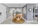 Dining area with a glass-top table and wicker chairs, adjacent to a modern kitchen at 504 Narvaezi St # 119, Venice, FL 34285