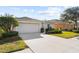 Exterior view of a house with a two-car garage and lush landscaping at 5198 Layton Dr, Venice, FL 34293