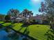 Private backyard retreat with screened lanai, lush lawn, and tranquil canal views at 5856 Helicon Pl, Sarasota, FL 34238