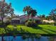Lush backyard with palm trees, a screened lanai, and a tranquil waterfront setting at 5856 Helicon Pl, Sarasota, FL 34238