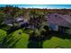 Aerial view of a backyard with palm trees, a screened-in patio, and green lawn at 5856 Helicon Pl, Sarasota, FL 34238