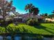 Backyard oasis with a screened lanai, manicured lawn, and serene water views at 5856 Helicon Pl, Sarasota, FL 34238
