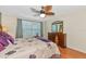 Bedroom with wooden furniture, ceiling fan, and large window with shutters at 5856 Helicon Pl, Sarasota, FL 34238