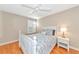 Charming bedroom with white furniture, floral bedding, ceiling fan, and wood floors at 5856 Helicon Pl, Sarasota, FL 34238