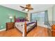 Inviting bedroom with wood floors, ceiling fan, and large window with shutters at 5856 Helicon Pl, Sarasota, FL 34238