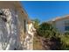 Side exterior view of a home with a walkway, green shutters, and landscaping at 5856 Helicon Pl, Sarasota, FL 34238