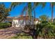 Front exterior of a home with attached garage, landscaped yard, and paver driveway at 5856 Helicon Pl, Sarasota, FL 34238