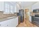 Modern kitchen featuring white cabinetry, stainless steel appliances, and a tile floor at 5856 Helicon Pl, Sarasota, FL 34238