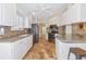 Updated kitchen with white cabinets, stainless steel appliances, and tile floor at 5856 Helicon Pl, Sarasota, FL 34238