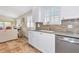 Clean white kitchen with stainless steel appliances, tile floor, and plantation shutters at 5856 Helicon Pl, Sarasota, FL 34238