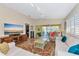 Inviting living room with tile floor, ceiling fan, and sliding glass doors to the patio at 5856 Helicon Pl, Sarasota, FL 34238
