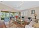 Spacious living room with a ceiling fan, sliding glass doors, and views of the patio and pond at 5856 Helicon Pl, Sarasota, FL 34238