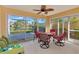 Spacious screened patio with a dining set and a view of the pond and landscaping at 5856 Helicon Pl, Sarasota, FL 34238