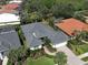 Aerial view of a home with a tile roof, lush landscaping, and a paver driveway in a golf community at 589 Pond Willow Ln, Venice, FL 34292