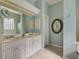 Bright bathroom featuring double sinks, ample counter space, and decorative mirrors at 589 Pond Willow Ln, Venice, FL 34292