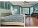 Serene bedroom with a large bed, shuttered windows, hardwood floors, and a sitting area at 589 Pond Willow Ln, Venice, FL 34292