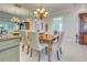 Elegant dining room with a chandelier, a large dining table, and a mirrored accent wall at 589 Pond Willow Ln, Venice, FL 34292