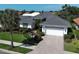 Attractive home featuring a tile roof, well-kept lawn, and a paver driveway leading to a two-car garage at 589 Pond Willow Ln, Venice, FL 34292
