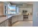 Well-lit kitchen with white cabinets, stainless steel appliances, and a corner sink with a view at 589 Pond Willow Ln, Venice, FL 34292