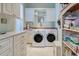 Bright laundry room with cabinets, counterspace, and a front load washer and dryer at 589 Pond Willow Ln, Venice, FL 34292
