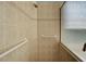 Tiled shower with grab bars and a glass door, offering accessibility and modern design at 589 Pond Willow Ln, Venice, FL 34292