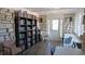 Cozy library with bookshelves, comfortable seating, and stone walls at 6297 Drucker Cir, Port Charlotte, FL 33981