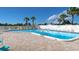 Community pool with lounge chairs, a white fence, and palm trees at 6297 Drucker Cir, Port Charlotte, FL 33981