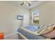 Bedroom featuring ceiling fan, wall-mounted TV, and large window at 6370 Falcon Lair Dr, North Port, FL 34287