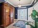 Elegant entryway with dark blue walls, wood cabinet, and patterned rug at 11301 Bertolini Dr, Venice, FL 34292