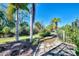 Landscaped backyard with palm trees and stone pathway at 11539 Okaloosa Dr, Venice, FL 34293