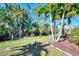 Landscaped backyard with palm trees and grassy area at 11539 Okaloosa Dr, Venice, FL 34293