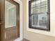 Brown front door with glass panels next to a window with white shutters at 11539 Okaloosa Dr, Venice, FL 34293