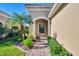 Brick walkway to covered entryway with arched window and lush landscaping at 11539 Okaloosa Dr, Venice, FL 34293