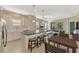 Open-concept kitchen with island seating, stainless steel appliances, and a view of the living area at 11539 Okaloosa Dr, Venice, FL 34293