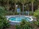 Relaxing hot tub surrounded by lush landscaping and a checkerboard patio at 1195 Collier Pl, Venice, FL 34293