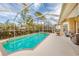 Inviting pool area with screened enclosure, comfortable seating, and lush landscaping at 125 Amora Ave, Venice, FL 34285