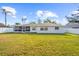 Large backyard with grassy lawn and screened patio at 1255 Paradise Way, Venice, FL 34285