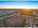 Aerial view of a serene neighborhood showcasing community pond and lush surroundings at sunset at 1307 Highland Greens Dr, Venice, FL 34285